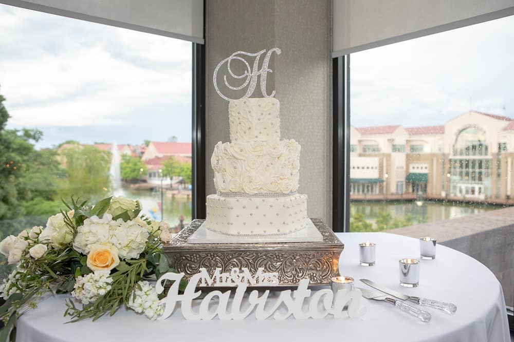 Wedding cake sitting on table with white pearls and silver sparkle at the Hilton Charlotte University Place